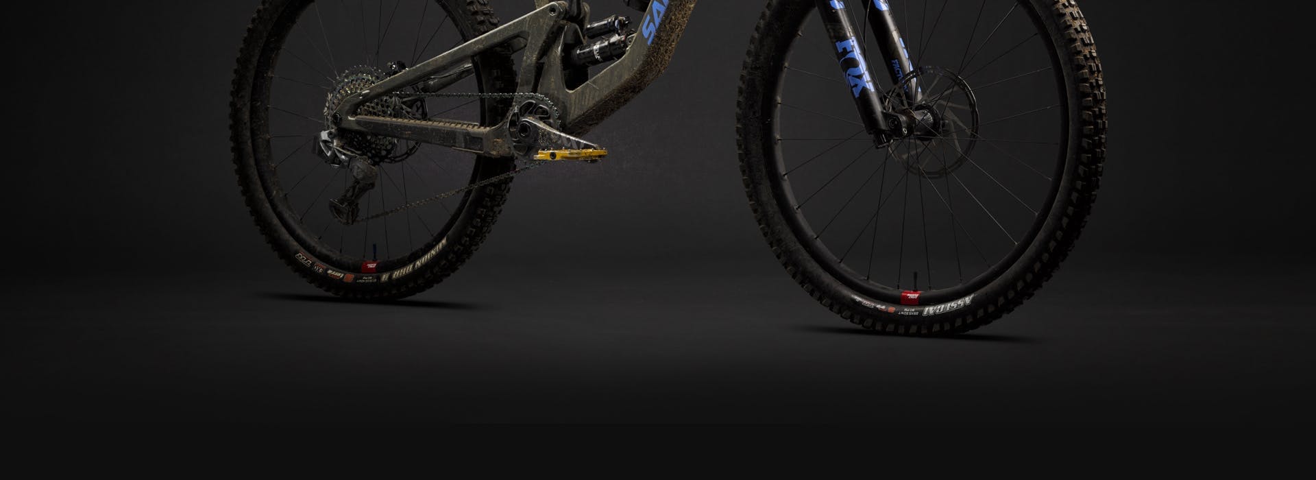 The bottom half of a Santa Cruz Bronson 4 mixed wheel full suspension mountain bike covered in dirt